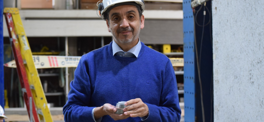 Investigador CIM UC-CENAMAD José Luis Almazán posa con aislador de movimiento sísmico para estructura de madera